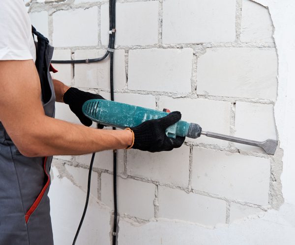 man-with-demolition-hammer-remove-stucco-from-wall-2023-11-27-05-13-17-utc